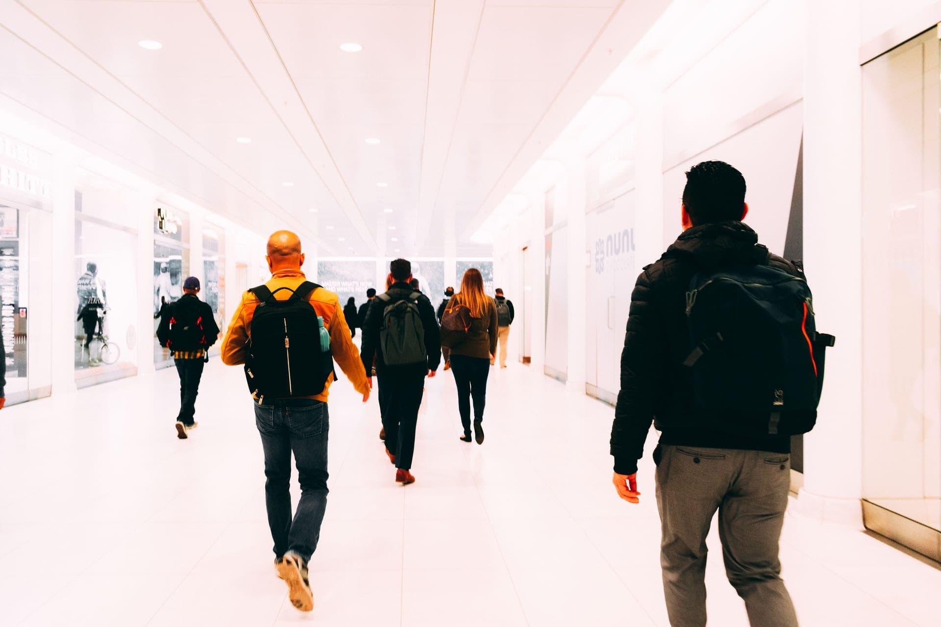 Travelers walking through an airport terminal hallway