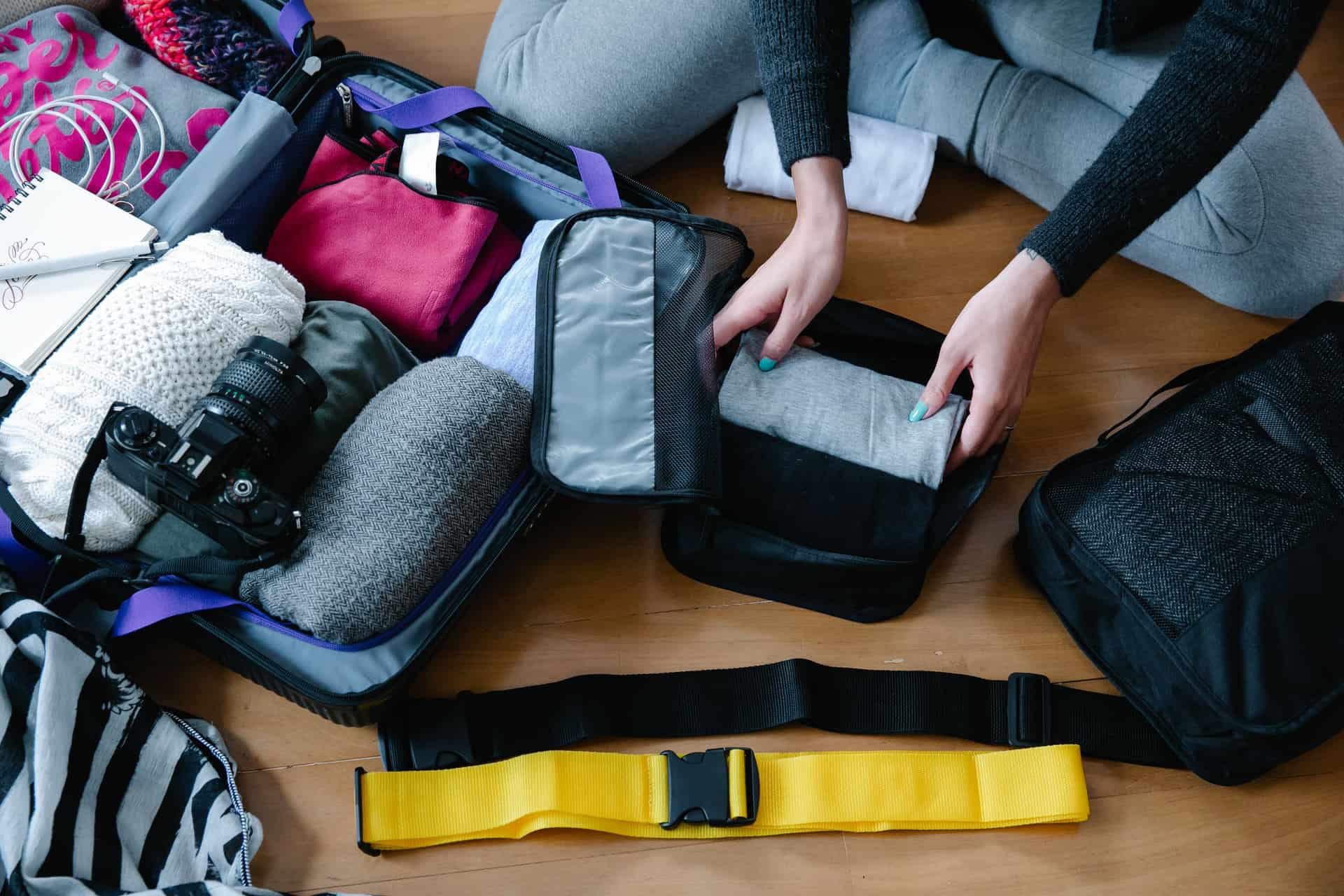 Folded clothes being organized into a bag for travel