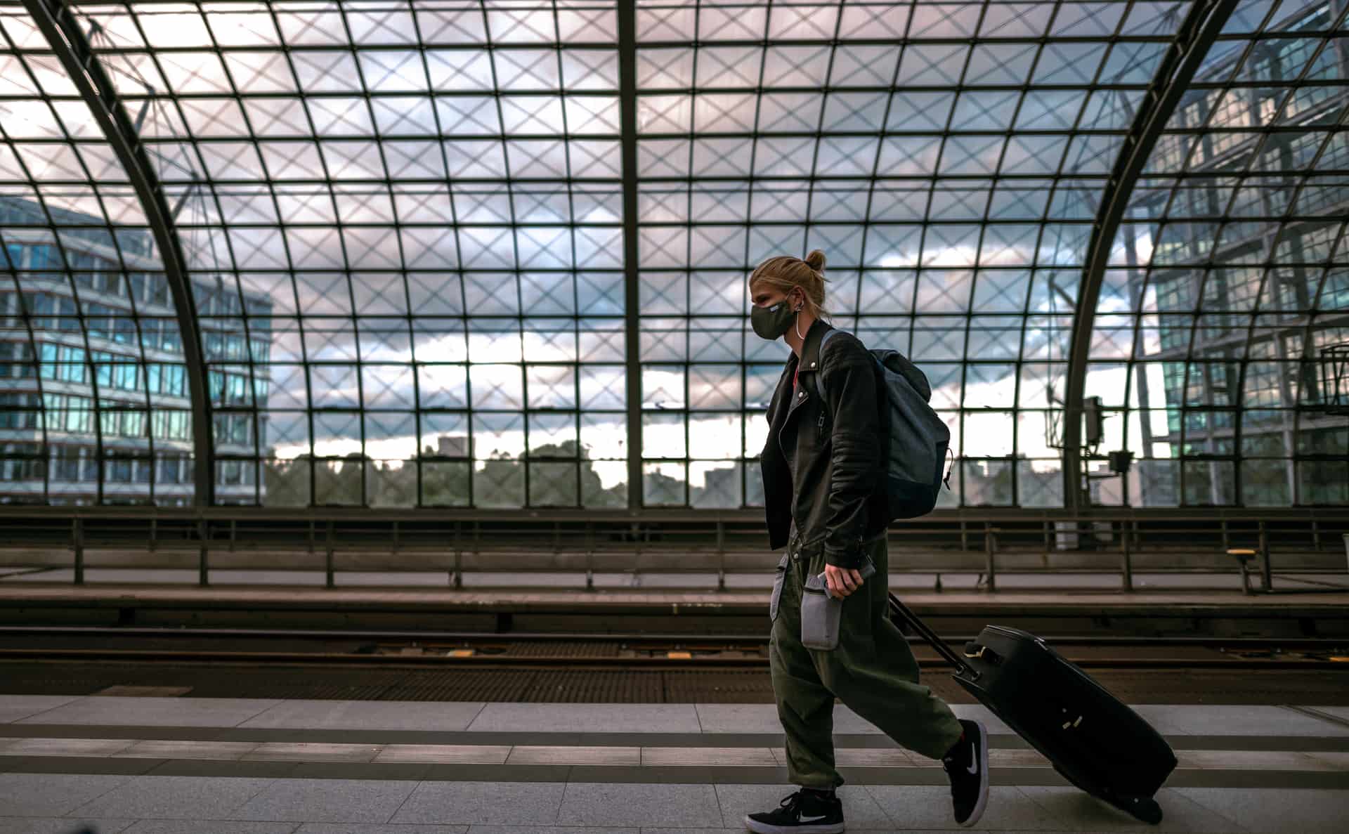 A traveler with luggage waiting at a railway station